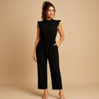 Women’s tailored jumpsuit with high round neckline, cap sleeves, and matching belt. A chic and elegant outfit for parties, dinners, or formal occasions.
